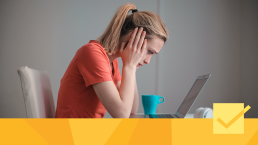 Banner for article about different types of peer review, showing a frustrated woman staring at a laptop.