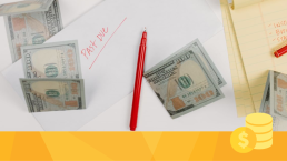 Money and a red pen on a pile of paperwork for overhead expenses.