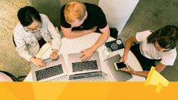 Three people sitting at a table discussing a marketing strategy.