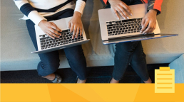 Two people on laptops using a submission system on their computers.